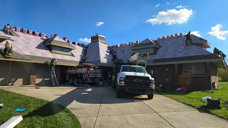Rick's Roofing crew and trucks on a siding and roofing project in Hendricks County